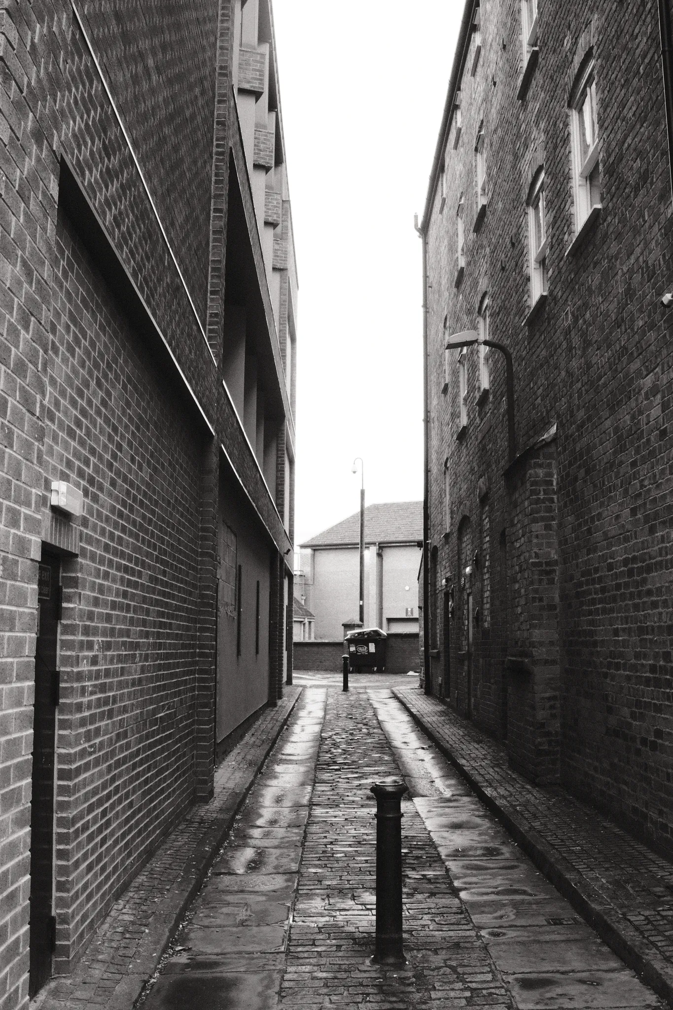 A narrow brick passage draws the eye towards a small patch of sky.