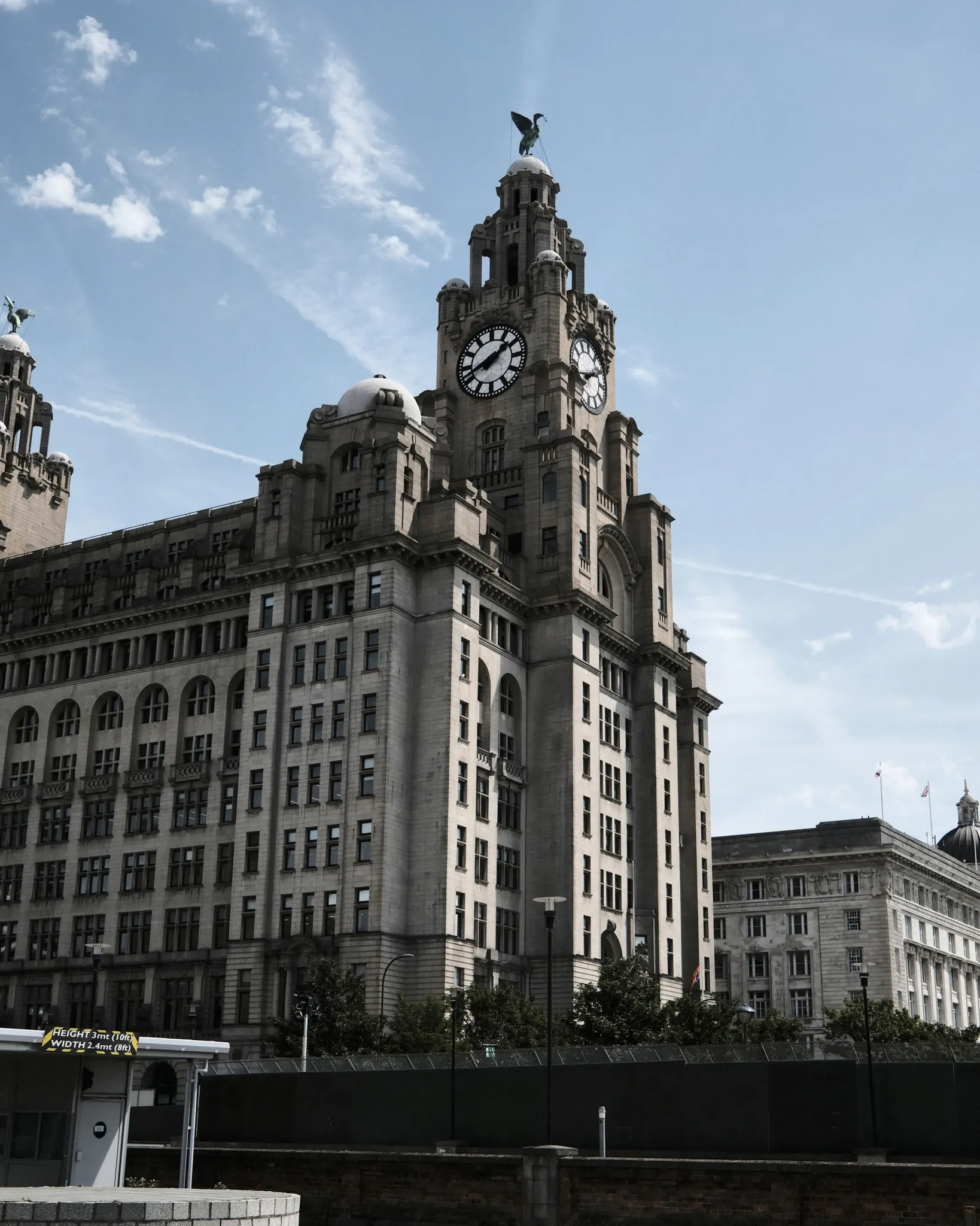 The Royal Liver Building seen across the road beneath a blue sky.