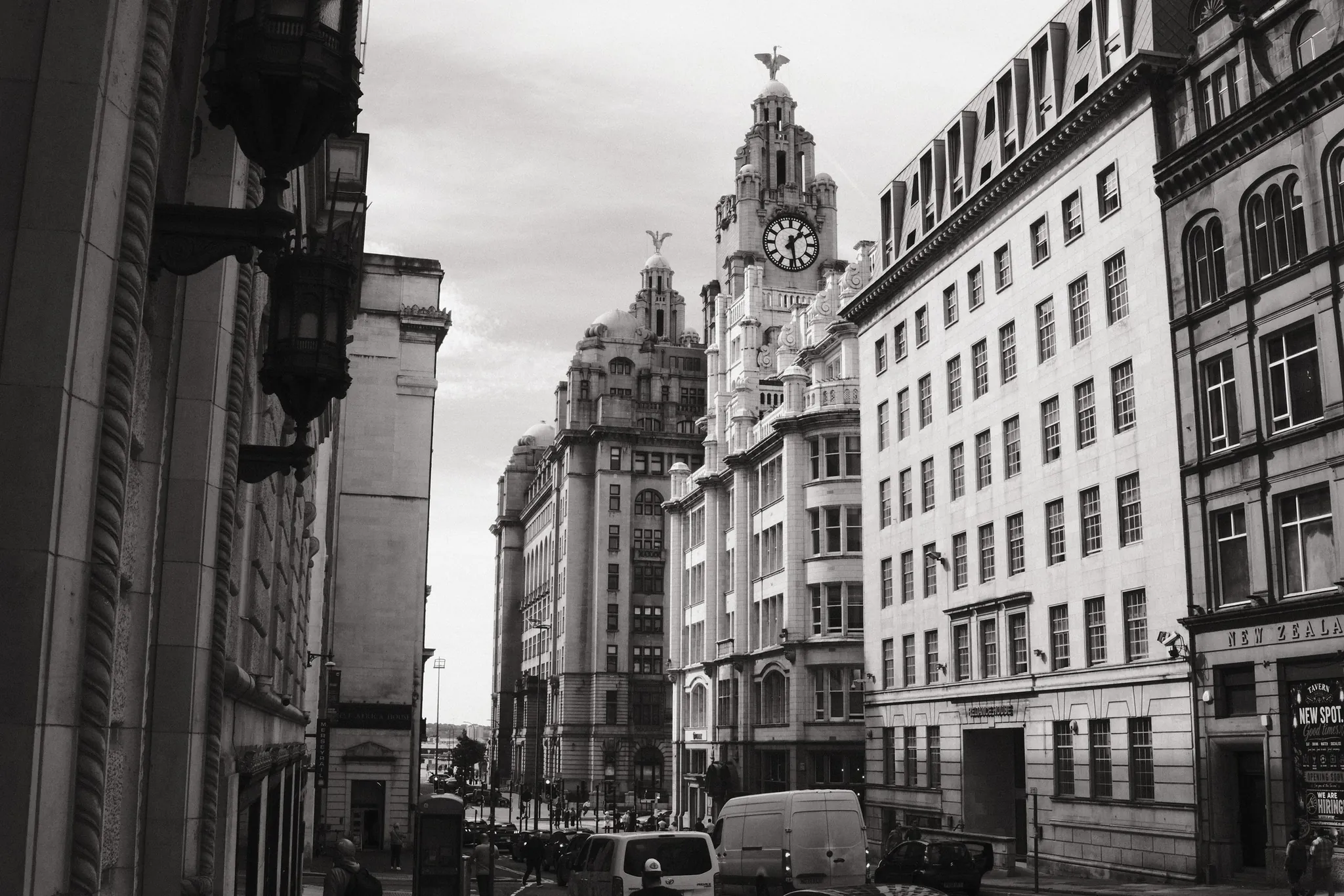 The Royal Liver Building rises at the end of Water Street, framed by tall stone façades in black and white.