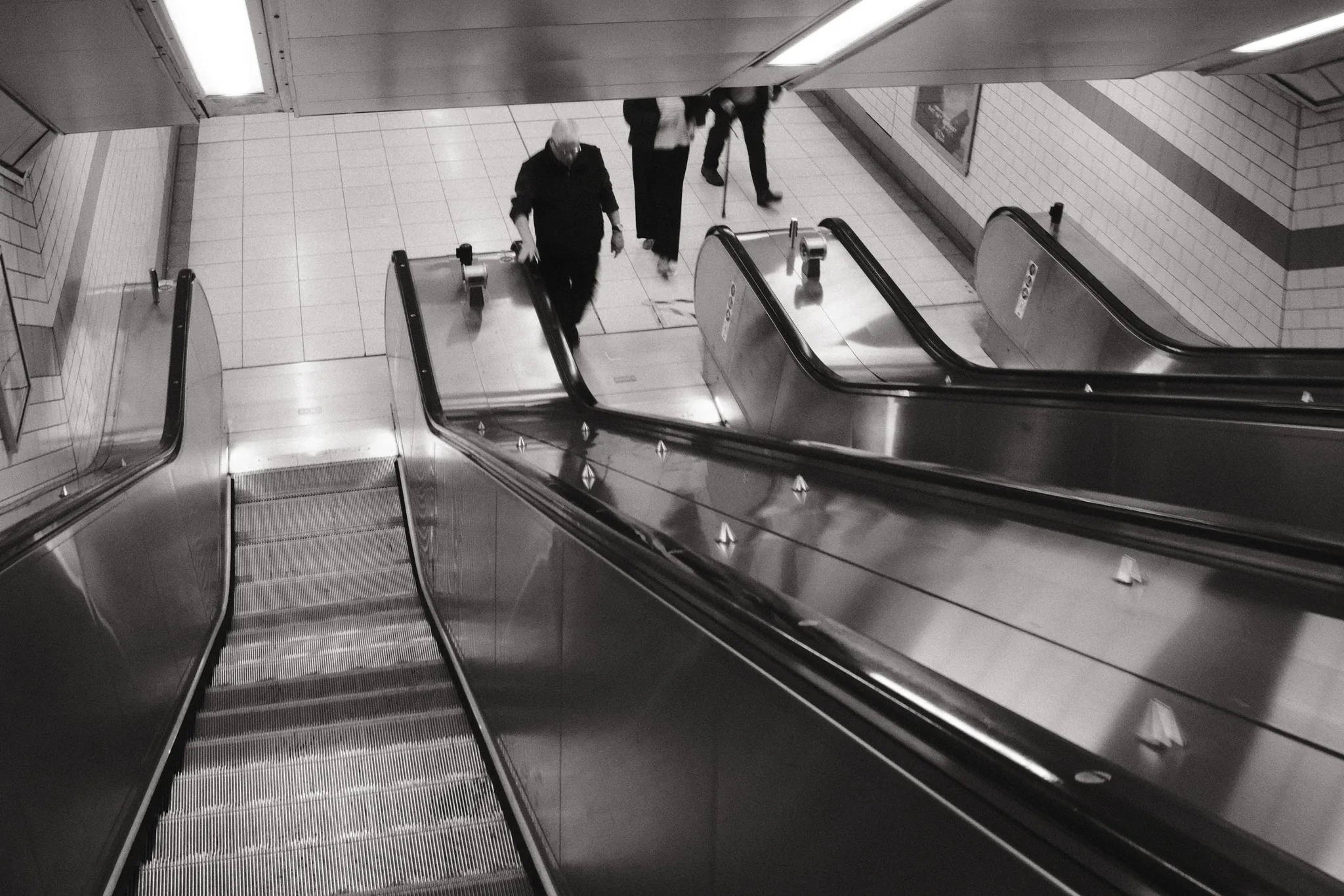 An overhead view of escalators and people moving between levels.