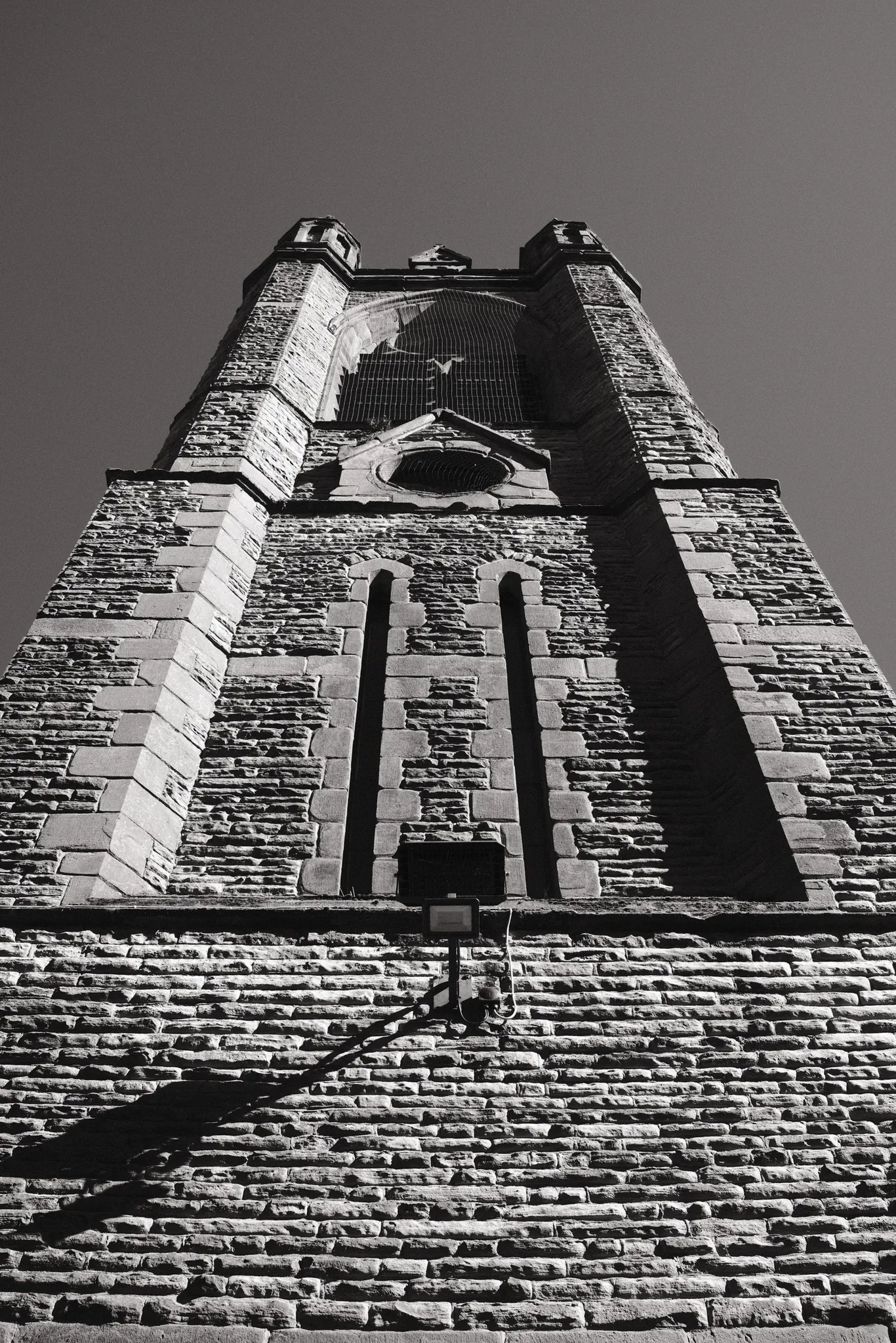 A low-angle view of a stone tower against a clear sky.