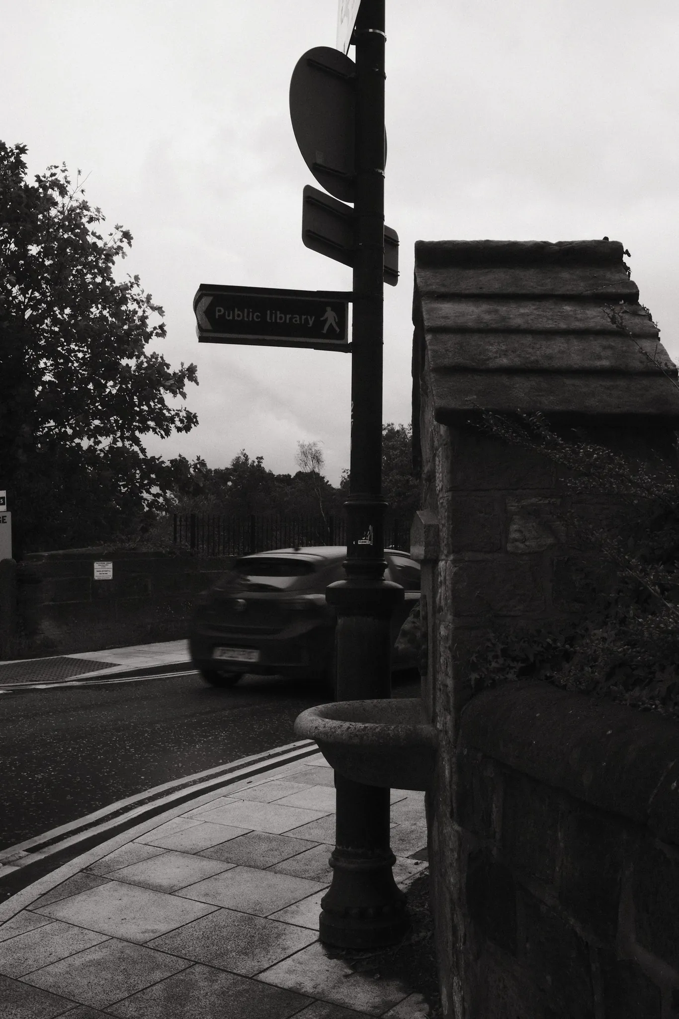 A crossing signal stands beside the historic drinking fountain built into Derby Street railway bridge.