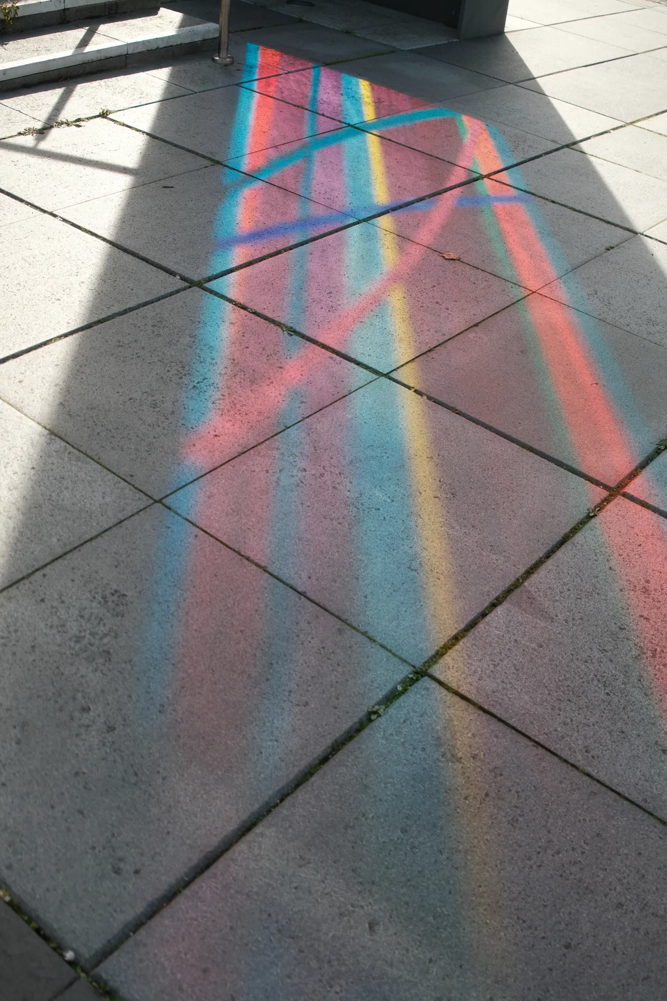 Coloured light falls in long bands across a tiled floor.