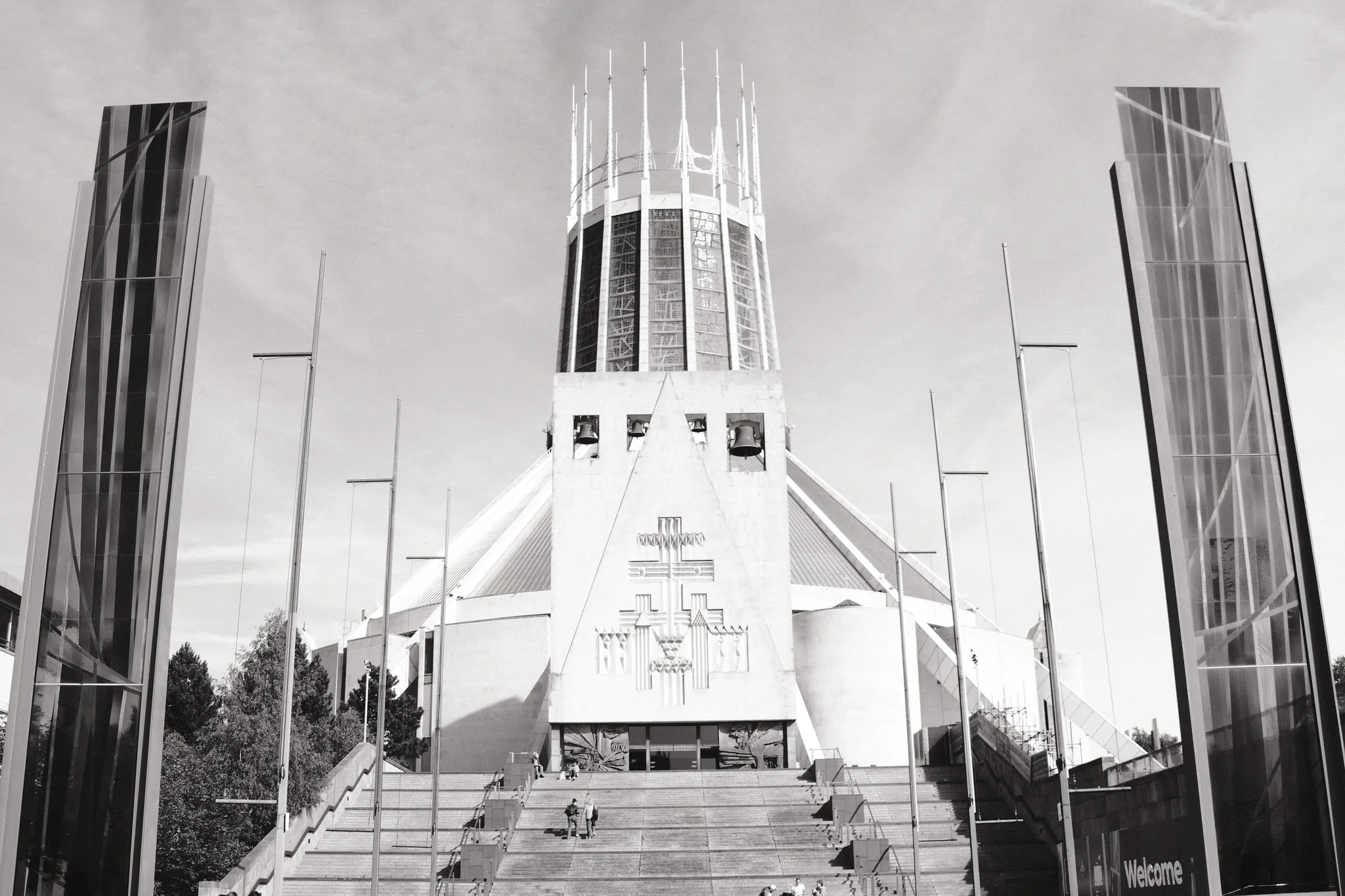 The front of Liverpool Metropolitan Cathedral is framed by tall concrete and glass structures.