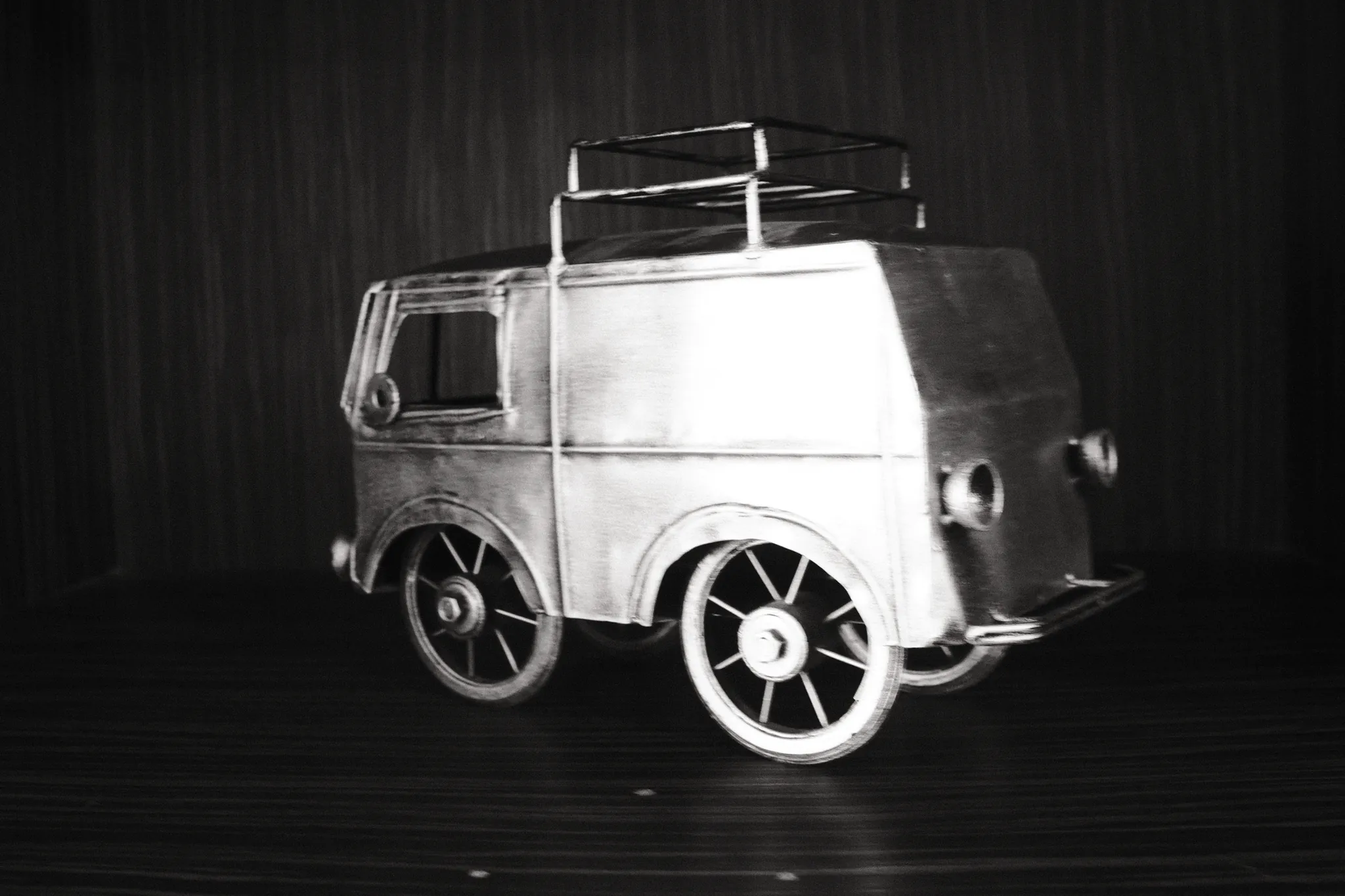 A small metal model van catches the light against a dark background.