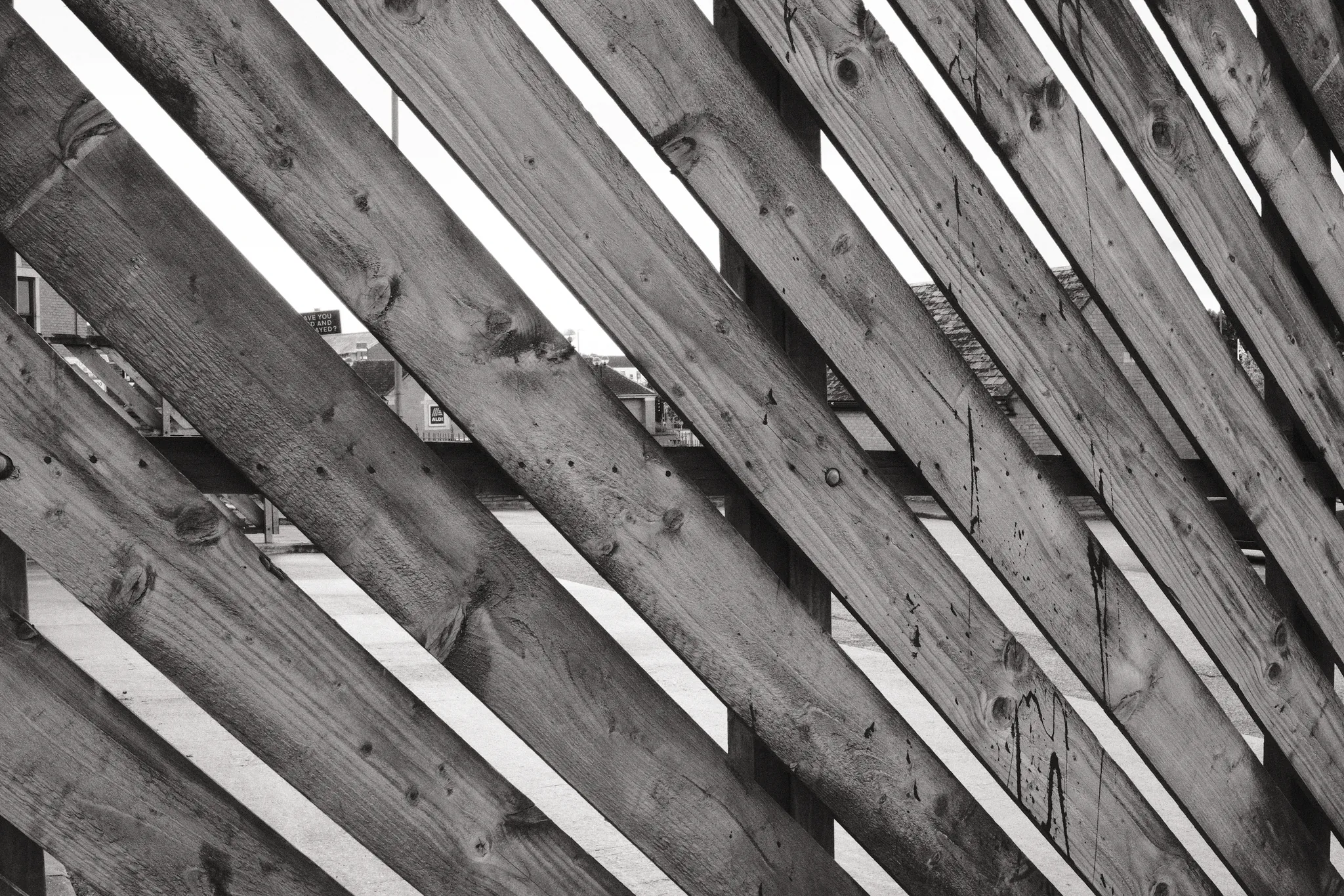Weathered timber slats form a repeating pattern of diagonal lines.